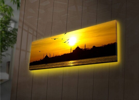 Lerretsbilde med LED belysning 30x90 cm Solnedgang over en bysilhuett med fugler i flukt Gull / Svart / Oransje