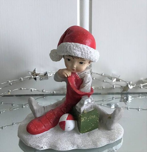 Julefigur Gutt sittende med julestrømpe