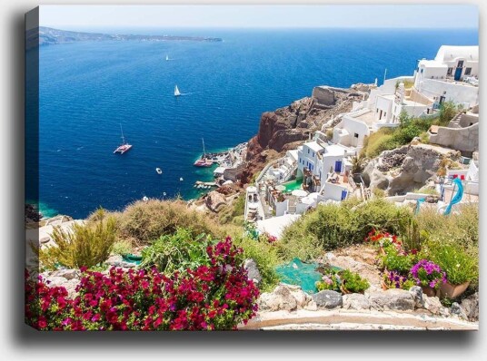 Lerretsbilde 70x100 cm Vakker utsikt over Santorini med hvite hus og blomster som pryder klippene ved havet Blå / Hvit / Grønn