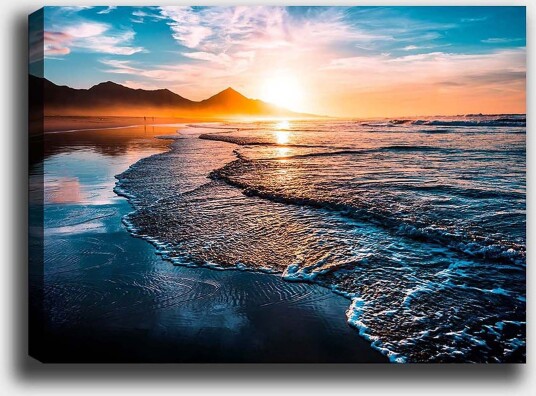 Lerretsbilde 70x100 cm Solnedgang over en strand med milde bølger som ruller inn mot kysten Blå / Oransje / Turkis