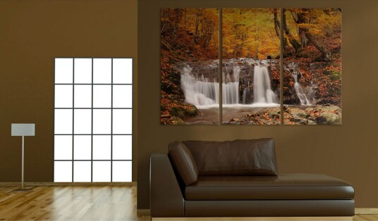 Bilde A waterfall in the middle of fall trees 90x60 Artgeist sp. z o. o.