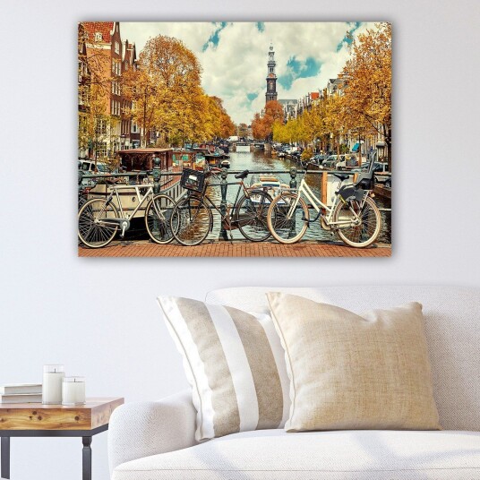 Lerretsbilde 70x100 cm Sykler ved en kanal i Amsterdam omgitt av høstfarger Gyllenoransje / Mørk blå / Hvit