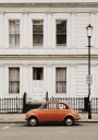 Charming Urban Scene with Orange Car Plakat Plakat / 70x100cm