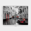 Lerretsbilde 70x100 cm Gondolier som navigerer gjennom en venetiansk kanal med fargerike detaljer i et svart hvitt miljø Rød / Grønn / Svart
