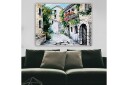 Lerretsbilde 70x100 cm Pittoresk smug med sjarmerende hus og blomstrende balkonger Grønn / Beige / Rød